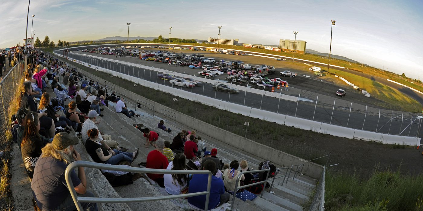 Packed grandstands overlooking the half-mile oval at sunset