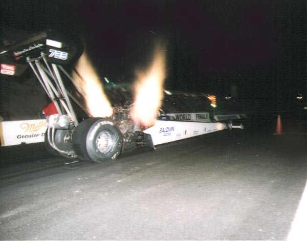 Dragster with header flames during a night race